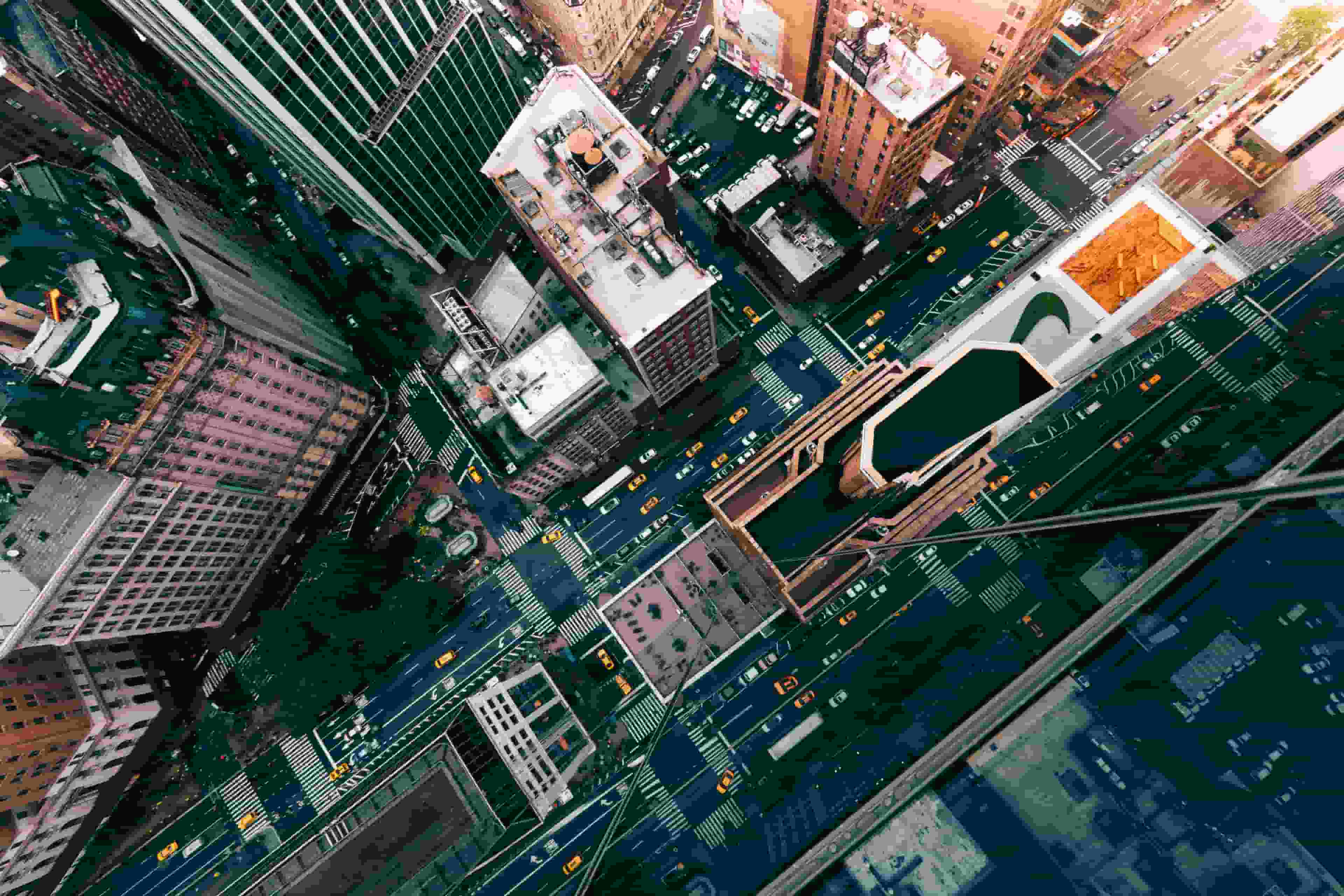 Photo of New York City streets filled with yellow taxi cabs, taken from on top of a building with a reflection of the streets.