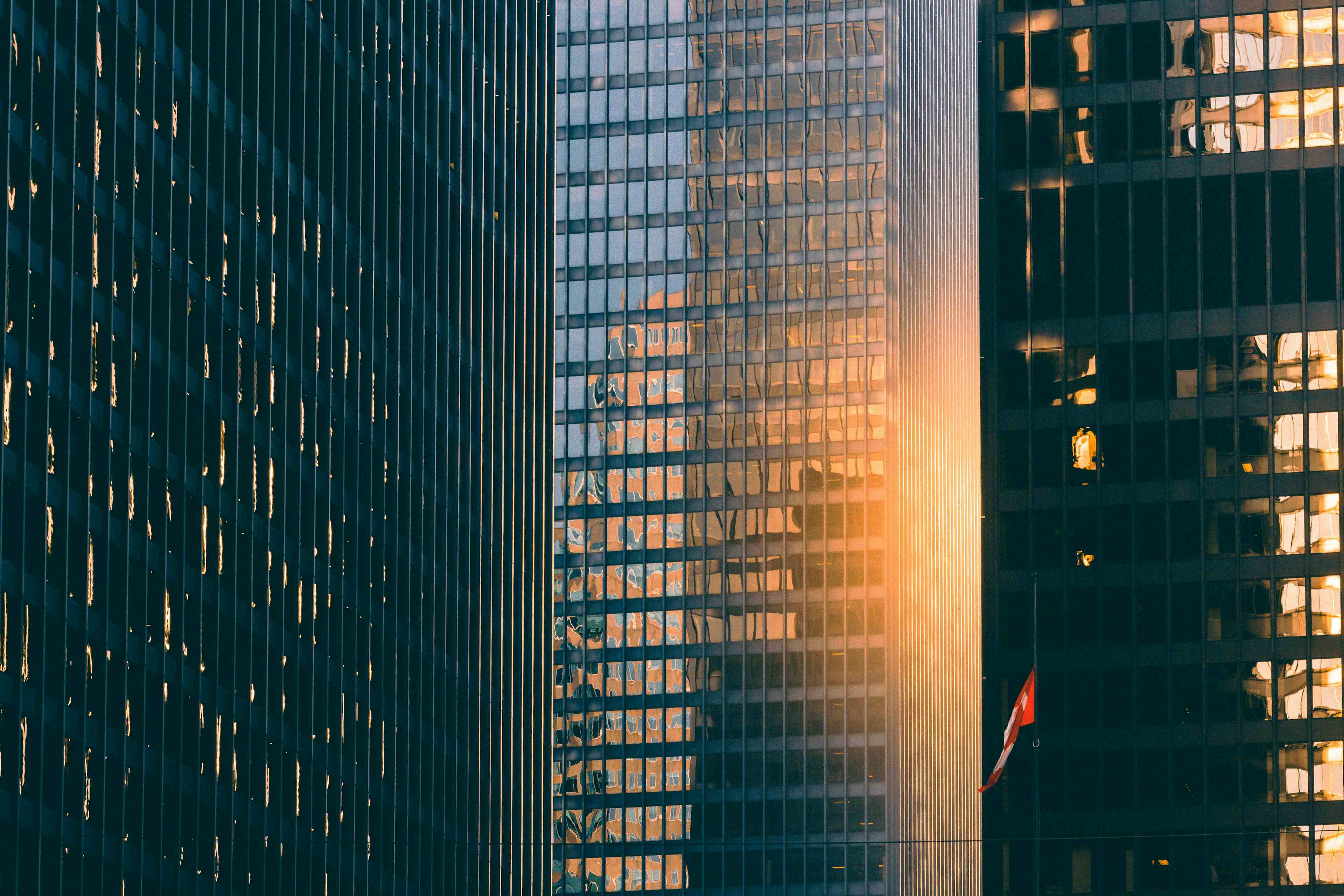 Patterned skyscrapers in Toronto, Canada standing close together with the sunlight shining through the middle of them